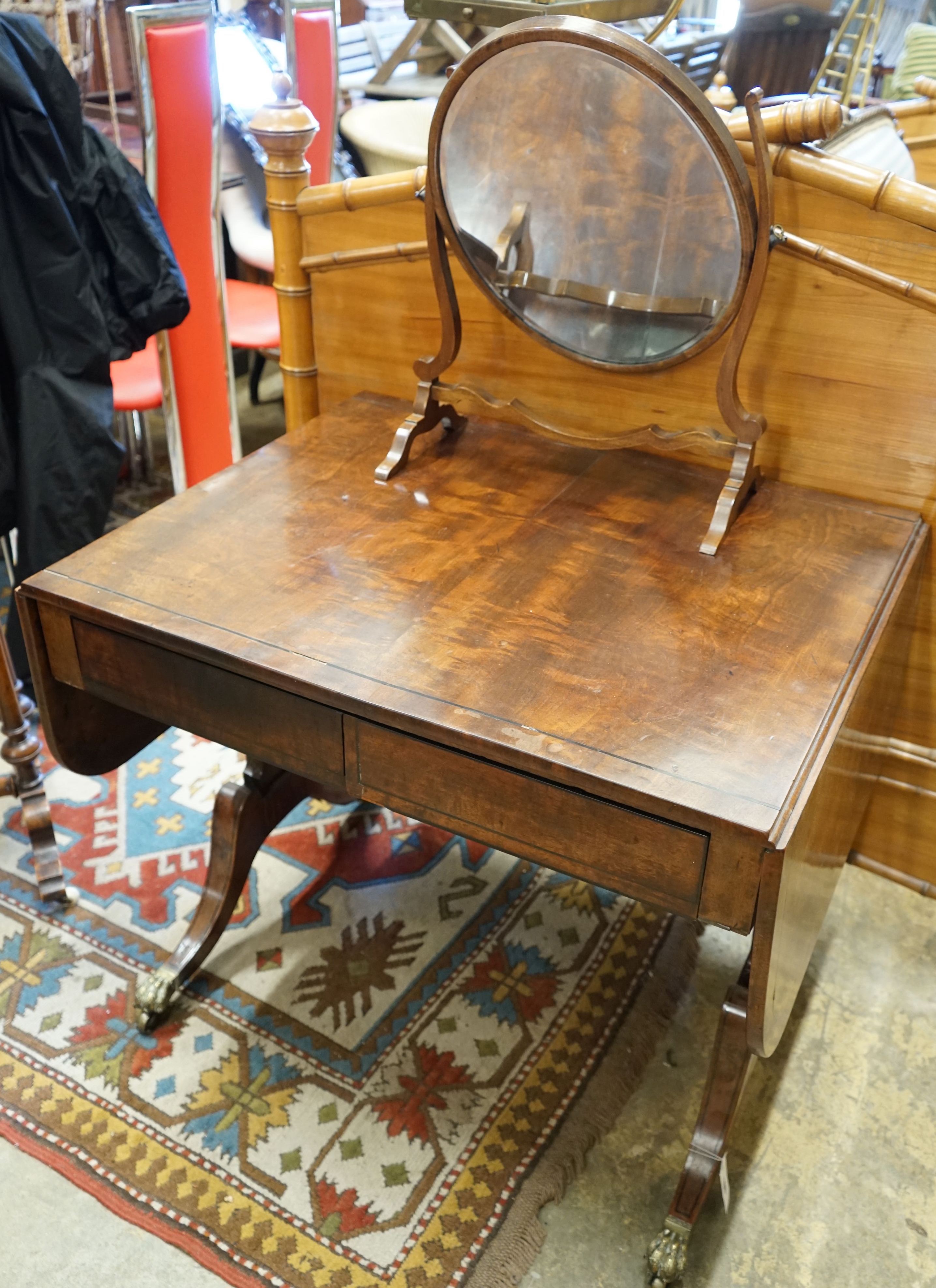 A Regency figured mahogany and ebony strung sofa table, width 83cm depth 66cm height 72cm, and a skeleton toilet mirror